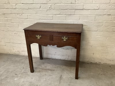 Lot 2385 - A Georgian oak two drawer side table on block...
