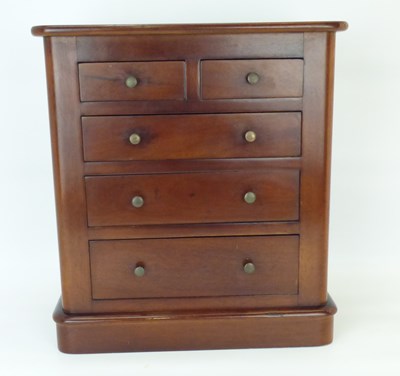 Lot 117 - A mahogany tabletop miniature chest of two-over-three graduated drawers