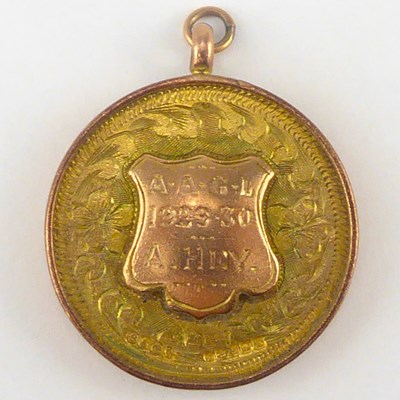 Lot 989 - A 9ct rose gold circular prize fob, the shield...