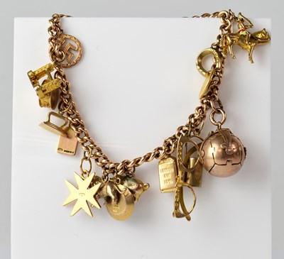 Lot 918 - A 9ct gold curb link chain charm bracelet with...