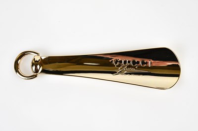 Lot 946 - GUCCI; a gold tone unused metal shoe horn...