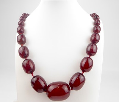 Lot 960 - A carnelian coloured amber-style continuous...