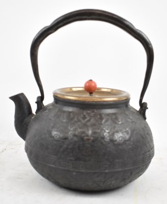 Lot 607 - An early Japanese cast iron kettle with swing...
