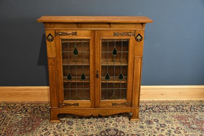 Lot 6504 - An Arts and Crafts light oak bookcase, with a...