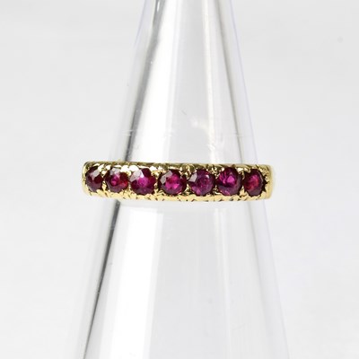 Lot 877 - A 9ct gold ruby set half eternity ring,...