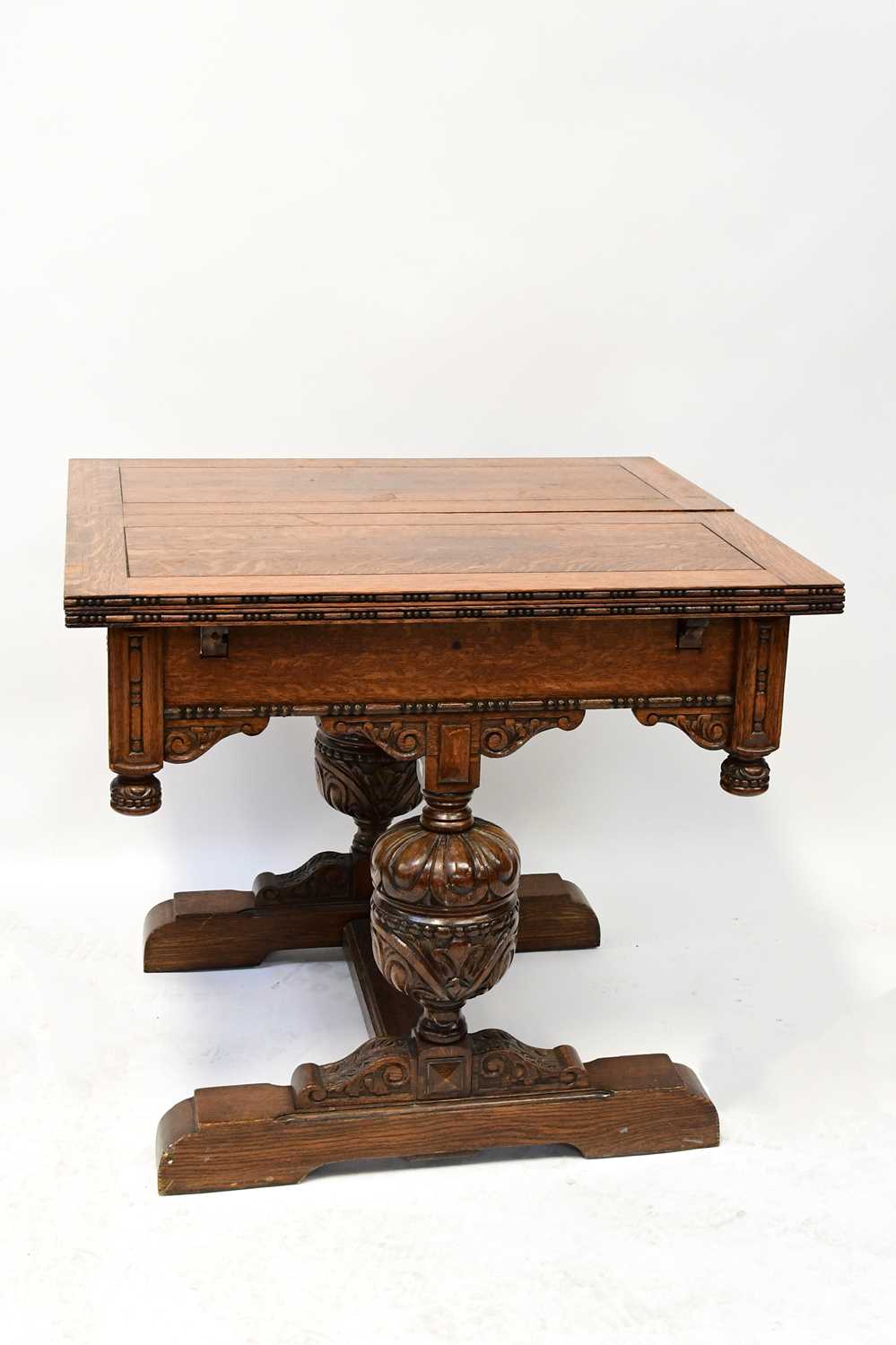 Lot 43 - An early 20th century oak fold-over draw-leaf...