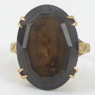 Lot 870 - A 9ct gold dress ring with oval cut smoky...