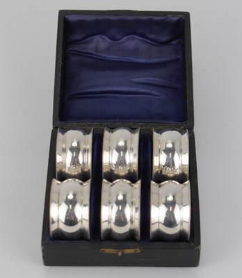 Lot 644 - A cased set of six silver plated napkin rings...