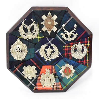 Lot 476 - An octagonal oak plaque bearing the cap badges...