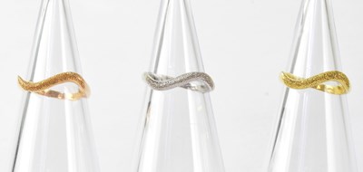 Lot 848 - An 18ct tricolour ring group with textured...