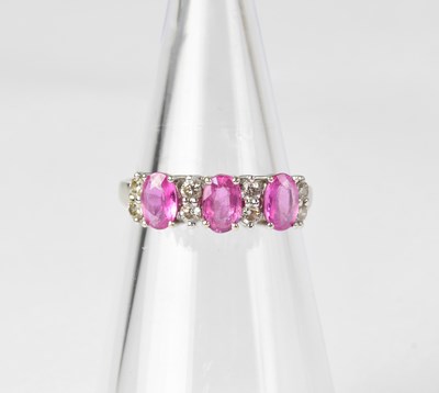 Lot 853 - A 14ct white gold ring set with three pink...
