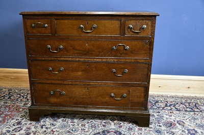 Lot 6517 - A late George III oak chest with three short...
