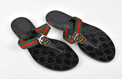 Lot 1056 - GUCCI; a pair of GG black leather flat thong...