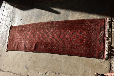 Lot 6480 - A red ground Bokhara runner, 273cm x 80cm.
