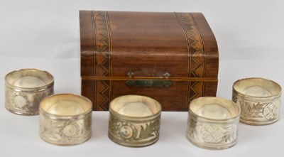 Lot 703 - A set of five cased silver plated napkin rings,...