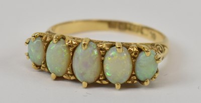 Lot 781 - An 18ct yellow gold ring set with five opals,...
