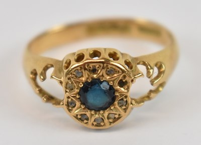 Lot 791 - An 18ct yellow gold ring set with central blue...