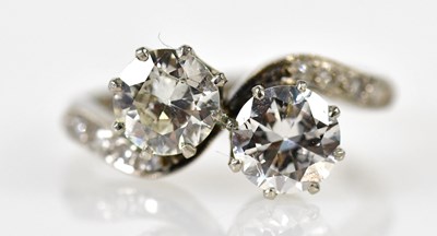 Lot 67 - A platinum and diamond crossover ring, each...