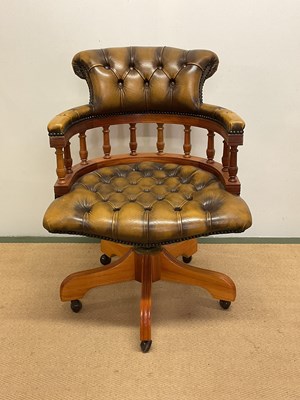 Lot 518 - A leather upholsterered swivel chair, height...