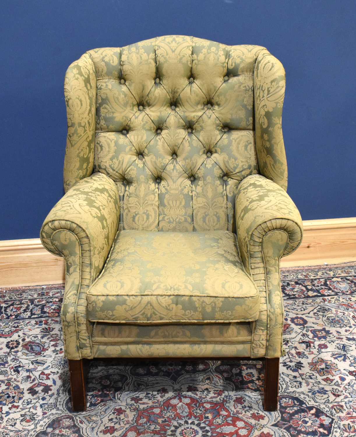 Lot 45 - A reproduction wing back armchair on square...