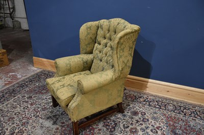 Lot 45 - A reproduction wing back armchair on square...