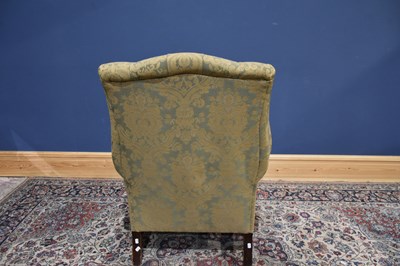 Lot 45 - A reproduction wing back armchair on square...