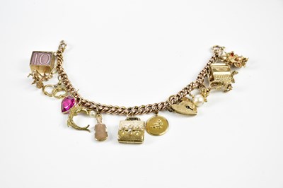 Lot 273 - A 9ct rose gold and yellow gold charm bracelet...