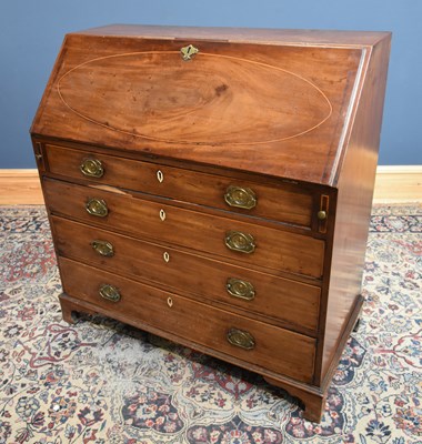 Lot 74 - A Georgian inlaid mahogany bureau, the fall...