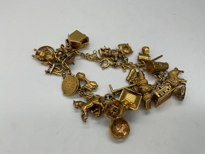 Lot 308 - A 9ct yellow gold charm bracelet with numerous...