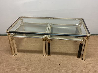 Lot 484 - A nest of three chrome/gold glass topped...