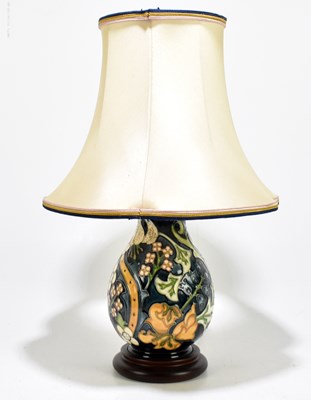 Lot 852 - MOORCROFT; a table lamp decorated with flowers...
