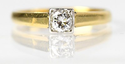 Lot 701 - An 18ct yellow gold ring set with a white...