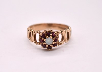 Lot 1121 - A 9ct yellow gold opal and garnet ring with...