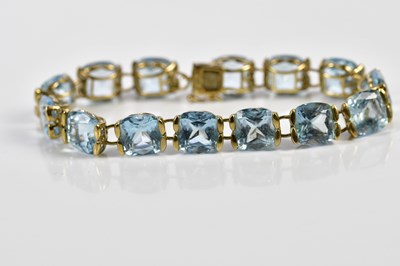 Lot 313 - A yellow metal pale blue stone set bracelet,...
