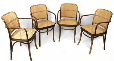 Lot 1556 - A set of four bent wood cane elbow chairs on...