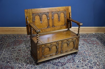 Lot 32 - A carved oak monk's bench with panelled front...