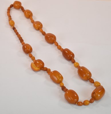 Lot 1269 - An early egg yolk/butterscotch amber bead...