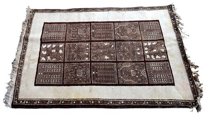 Lot 1209 - A cream and brown ground rug with central...