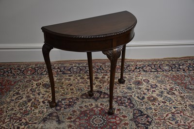 Lot 1124 - A mahogany demi-lune foldover games table on...