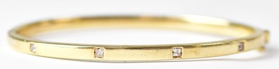Lot 748 - A 9ct yellow gold hinged bangle, set with...