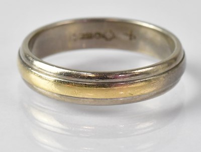 Lot 710 - An 18ct white and yellow gold wedding band,...