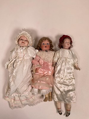 Lot 337 - A collection of three dolls; a bisque shoulder...