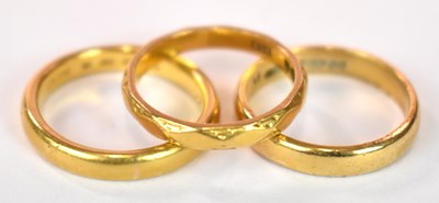 Lot 1235 - Three 22ct yellow gold wedding bands, combined...