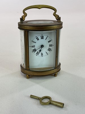 Lot 1361 - A circa 1900 French oval brass carriage clock...