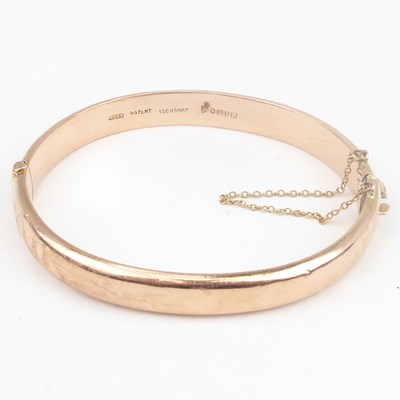 Lot 747 - A 9ct rose gold hinged bracelet with safety...