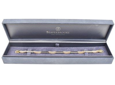 Lot 744 - A 9ct gold bracelet, open and solid links with...