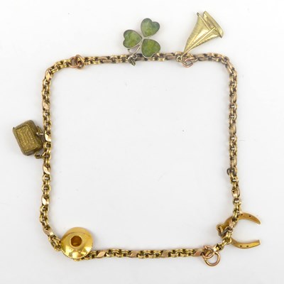 Lot 749 - A charm bracelet with a 10k wishbone charm, a...