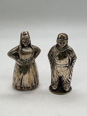 Lot 1086 - Two Dutch white metal figural pepperettes, one...