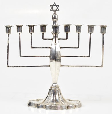 Lot 2078 - A white metal menorah with applied floral and...