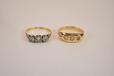 Lot 1153 - A yellow metal three stone diamond ring, size...